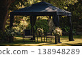 Garden tent set up for a gathering in the afternoon sun with tables and flowers 138948289