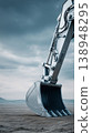 Excavator digs into the ground under a cloudy sky in a construction site 138948295