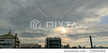 Behind the clouds there is a sunset 138948469