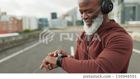Man, music and smart watch in city for workout, cardio performance and exercise results. Happy senior african runner, sports gear and timer for clock, healthy training progress and headphones in road 138948591