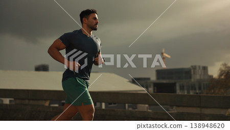 Running, city or man with workout in training, cardio jog or fitness for marathon competition. athlete, wellness or strong body for france with progress, road or health lifestyle and overcast sky 138948620