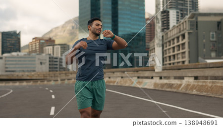 Time, fitness and a man running in the city for sports training, getting ready for a marathon or race. Watch, exercise and a young runner or athlete outdoor in an urban town for his workout routine 138948691