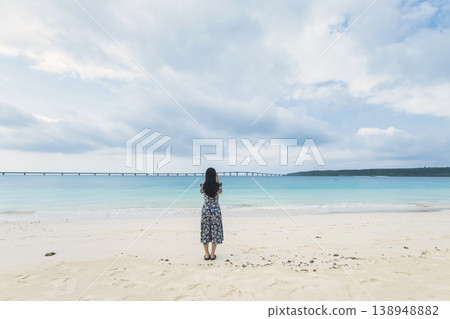 A woman looking at Kurima Bridge from Yonaha Maehama Beach. A woman looking at Kurima Bridge from Yonaha Maehama Beach. 138948882