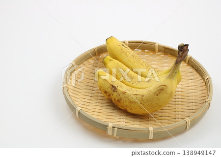 一串新鮮飽滿的香蕉放在竹籃裡。 一串新鮮飽滿的香蕉放在竹籃裡。 138949147