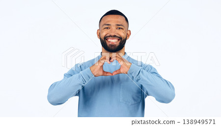 Heart, hands and portrait of man in studio for kindness, happy icon and charity donation on white background. Smile, love and emoji sign for hope, wellness and thank you for support, care and peace 138949571