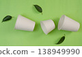 Biodegradable cups on green background with leaves 138949990