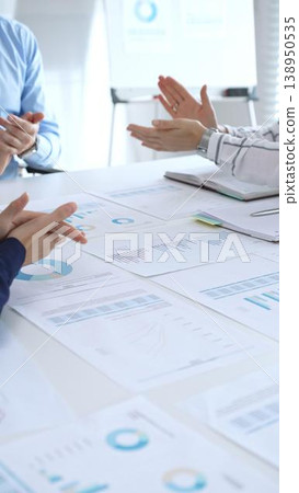 Business people team clapping hands in meeting celebrating success with financial charts, data analysis, sales growth reports, and teamwork achievement in modern office Business people team clapping hands in meeting celebrating success with financial charts, data analysis, sales growth reports, and teamwork achievement in modern office 138950535