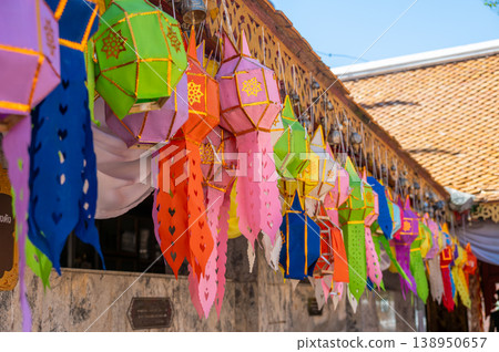 Colorful Thai religious flags hanging from roof, decorative elements in temple, vibrant cultural scene with traditional ornaments, symbol of spirituality and celebration 138950657
