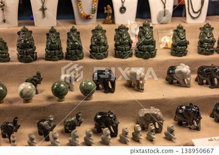 Ceramic statues of elephants and Buddha figures displayed at a street market stall in Thailand, waiting to be sold among other souvenirs and handmade crafts in vibrant street life. Ceramic statues of elephants and Buddha figures displayed at a street market stall in Thailand, waiting to be sold among other souvenirs and handmade crafts in vibrant street life. 138950667