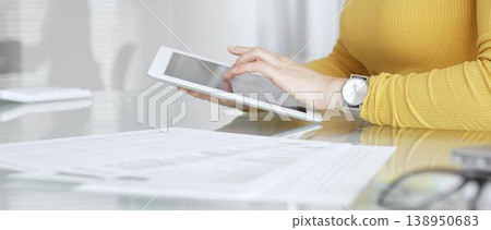 Woman working on digital tablet in office, accessing business documents and technology data. Audit and taxes in business 138950683