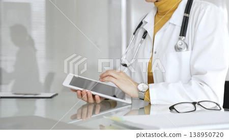 Female doctor using digital tablet, providing modern healthcare and medical technology consultation. Medicine, healthcare and science concept Female doctor using digital tablet, providing modern healthcare and medical technology consultation. Medicine, healthcare and science concept 138950720