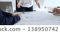 Business team analyzing financial charts and data reports during strategy meeting, hands pointing to documents on table with graphs and diagrams for planning 138950742