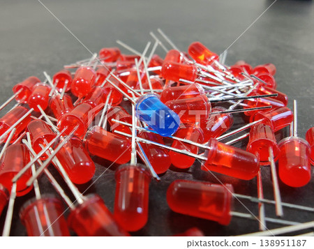 Red LED diodes with one blue diode standing out, electronic components concept Red LED diodes with one blue diode standing out, electronic components concept 138951187