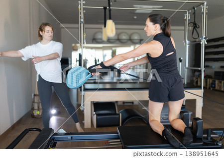 Women training together during reformer pilates session 138951645