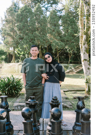 Couple looking at camera with giant chess pieces, strategy and relationship concept Couple looking at camera with giant chess pieces, strategy and relationship concept 138952492
