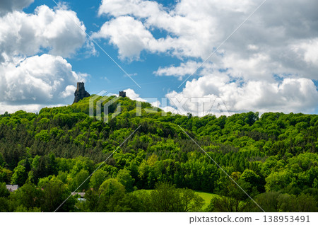 Panoramic view of Cesky Raj landscape in summer with iconic Trosky castle towers rising above green countryside under blue sky with dramatic clouds summer scenic natureview stock Panoramic view of Cesky Raj landscape in summer with iconic Trosky castle towers rising above green countryside under blue sky with dramatic clouds summer scenic natureview stock 138953491