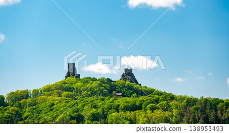 Panoramic view of Cesky Raj landscape in summer with iconic Trosky castle towers rising above green countryside under blue sky with dramatic clouds summer scenic natureview stock 138953493