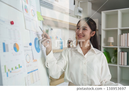 Businesswoman analyzing data on a whiteboard in an office 138953697