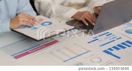 Business professionals analyzing financial data and charts Business professionals analyzing financial data and charts 138953699