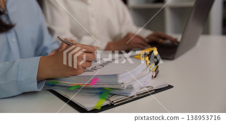 Team reviewing financial documents and reports in office Team reviewing financial documents and reports in office 138953716