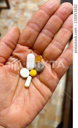 Pills and capsules in a woman's hand that a person is preparing to drink Pills and capsules in a woman's hand that a person is preparing to drink 138953882