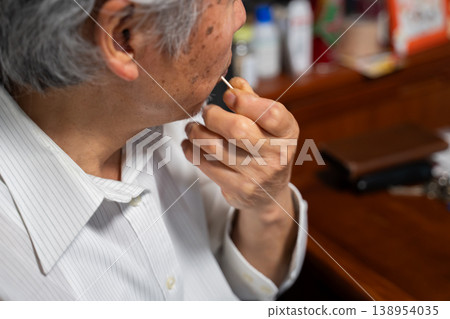 一位老人正在使用牙籤 一位老人正在使用牙籤 138954035