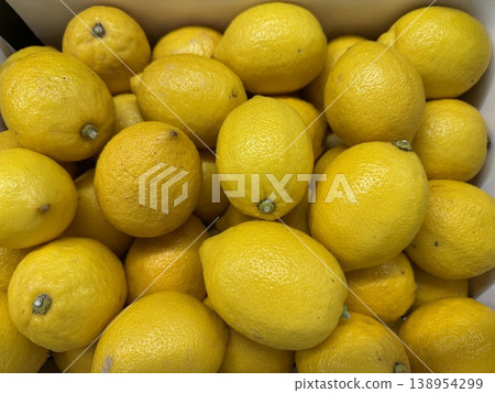 Lemons piled together creating a vibrant yellow background with smooth textures and organic forms Lemons piled together creating a vibrant yellow background with smooth textures and organic forms 138954299