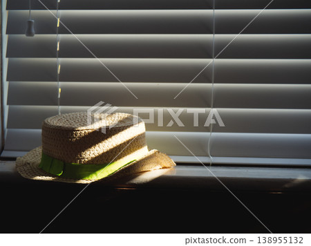 Straw hat in dappled sunlight window light 138955132