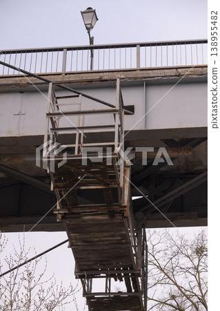 Low Angle View of Rusty Metal Maintenance Platform and Steel Bridge Structure Under Overcast Sky Low Angle View of Rusty Metal Maintenance Platform and Steel Bridge Structure Under Overcast Sky 138955482
