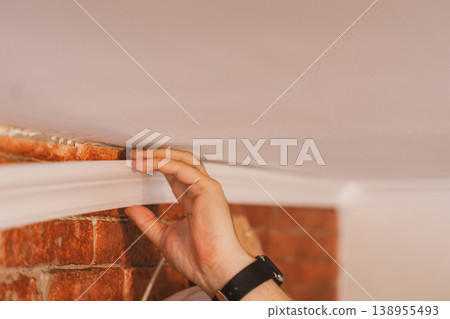 Close up applying construction adhesive to molding strip, DIY home improvement concept Close up applying construction adhesive to molding strip, DIY home improvement concept 138955493
