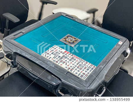 A blue felt mahjong table and mahjong tiles for a three-player game. A blue felt mahjong table and mahjong tiles for a three-player game. 138955499