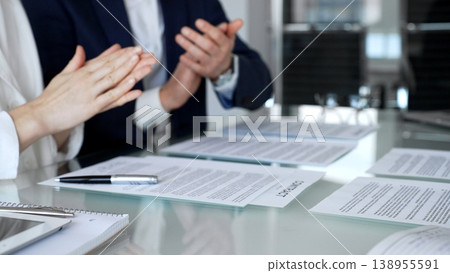 Business people applauding a successful agreement, signing legal contracts at a corporate office meeting, celebrating collaboration and mutual partnership achievement Business people applauding a successful agreement, signing legal contracts at a corporate office meeting, celebrating collaboration and mutual partnership achievement 138955591