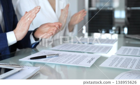 Business people applauding a successful agreement, signing legal contracts at a corporate office meeting, celebrating collaboration and mutual partnership achievement Business people applauding a successful agreement, signing legal contracts at a corporate office meeting, celebrating collaboration and mutual partnership achievement 138955626