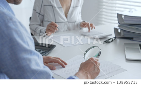 Groupe of accounting professionals analyzing financial documents, checking spreadsheet details with calculator and magnifying glass. Audit and taxes concept 138955715