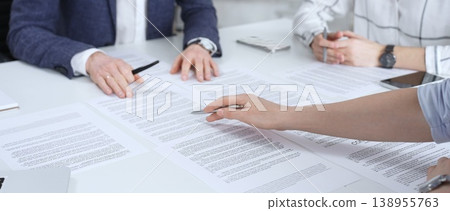 Business people discussing contract terms, outlining agreements, and reviewing legal documents during a corporate meeting, preparing for a significant partnership signing and negotiation Business people discussing contract terms, outlining agreements, and reviewing legal documents during a corporate meeting, preparing for a significant partnership signing and negotiation 138955763