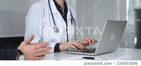 Doctor woman consulting male patient using laptop, discussing health information during medical examination at clinic office. Medicine, healthcare and science concept 138955806