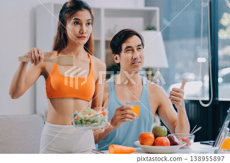 A happy couple prepares fresh vegetables, laughing and enjoying cooking a healthy meal together. A happy couple prepares fresh vegetables, laughing and enjoying cooking a healthy meal together. 138955897