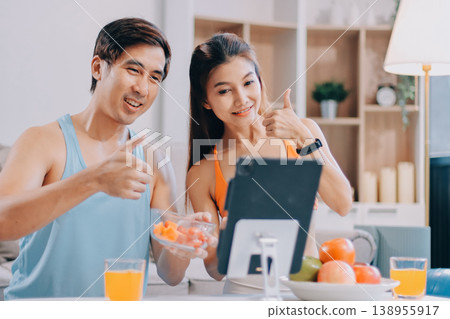 A happy couple prepares fresh vegetables, laughing and enjoying cooking a healthy meal together. A happy couple prepares fresh vegetables, laughing and enjoying cooking a healthy meal together. 138955917