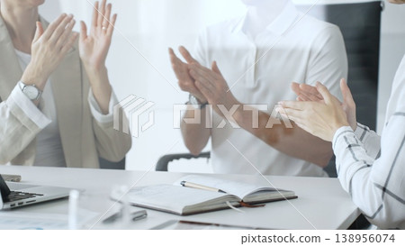 Business team applauding after achieving a goal during a productive meeting in a modern office environment, celebrating success and teamwork, close up 138956074