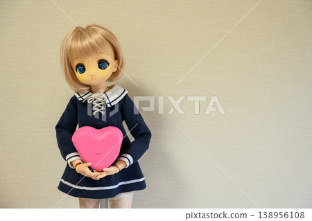 A cute doll holding a heart-shaped object - Valentine's Day portrait image A cute doll holding a heart-shaped object - Valentine's Day portrait image 138956108