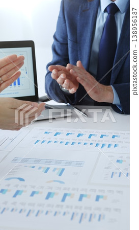 Business team clapping hands, celebrating financial success and achievement after a successful company presentation showing charts and data on a laptop screen 138956187