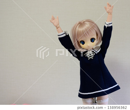 Cute doll posing, girl with bob hair and a dress, simple background. 138956362
