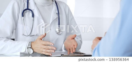Doctor discussing medical information with patient during consultation, showing healthcare advice and diagnostic data on laptop. Medicine, healthcare and science concept Doctor discussing medical information with patient during consultation, showing healthcare advice and diagnostic data on laptop. Medicine, healthcare and science concept 138956364