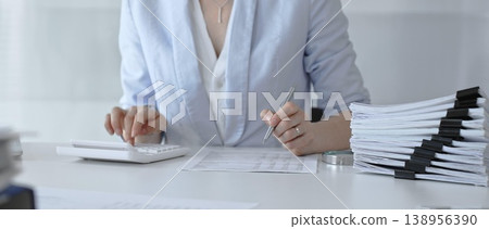 Professional woman calculating taxes, managing budget and financial paperwork, analyzing corporate accounting data, planning business finance strategies in modern office. Audit and taxes Professional woman calculating taxes, managing budget and financial paperwork, analyzing corporate accounting data, planning business finance strategies in modern office. Audit and taxes 138956390