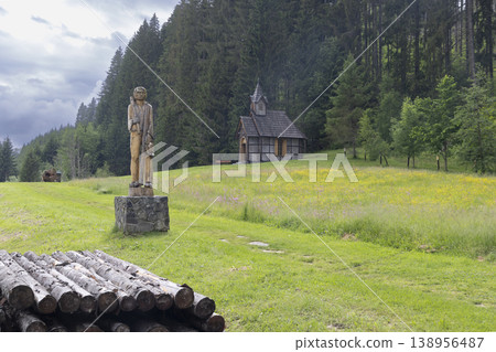Wooden sculpture and chapel in natural mountain forest Wooden sculpture and chapel in natural mountain forest 138956487