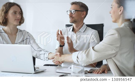 Businesswomen partners are shaking hands after successful negotiation, colleagues clapping, celebrating agreement in modern office headset. Handshake concept Businesswomen partners are shaking hands after successful negotiation, colleagues clapping, celebrating agreement in modern office headset. Handshake concept 138956547