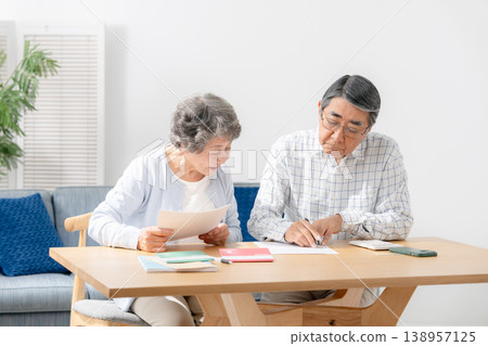 一對老年夫婦正在填寫臨終關懷計劃的相關文件。 一對老年夫婦正在填寫臨終關懷計劃的相關文件。 138957125