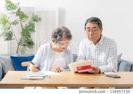 一對老年夫婦正在填寫臨終關懷計劃的相關文件。 一對老年夫婦正在填寫臨終關懷計劃的相關文件。 138957130