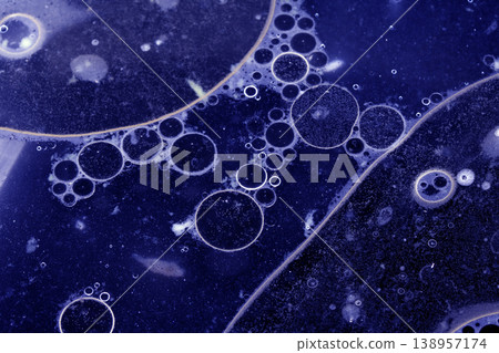 Close up of grease oil bubbles in water abstract blue background Close up of grease oil bubbles in water abstract blue background 138957174