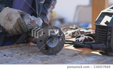 Closehand Craft With Sparks Involved. Precision Work On Metallic Circular Flange Surface. Intricate Tactile Craftsmanship Involving Sparks And Textured Metal On Circular Flange Closehand Craft With Sparks Involved. Precision Work On Metallic Circular Flange Surface. Intricate Tactile Craftsmanship Involving Sparks And Textured Metal On Circular Flange 138957689